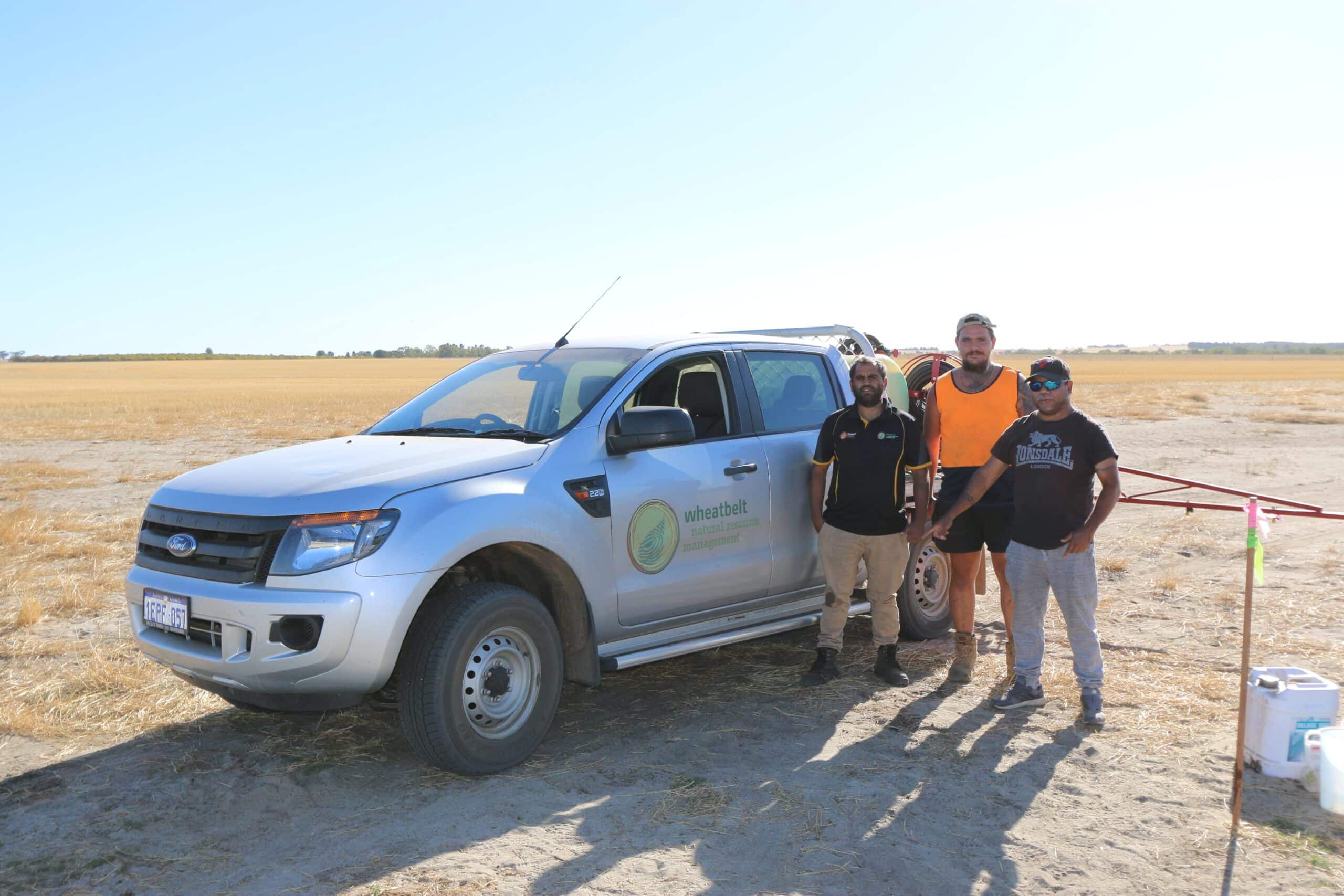 Three men standing in front of a silver ute
